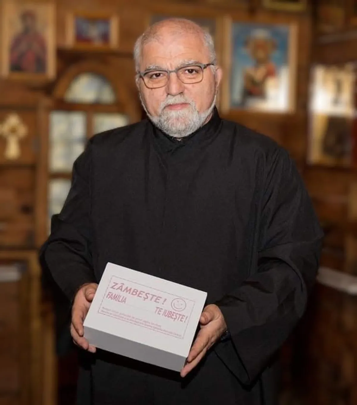 Pr. Ion Doru Iagăru în biserica spitalului din Caracal, cu o cutie din campania „Zâmbește! Familia (noastră) te iubește!”